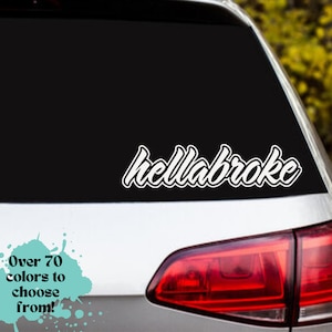 May include: A white vinyl decal with the text "hellabroke" in a stylized font, applied to the rear window of a silver car.