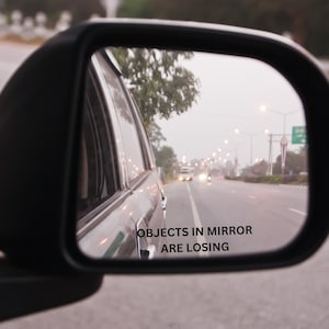 May include: A rearview mirror with the text "Objects in mirror are losing" printed on the bottom of the mirror.