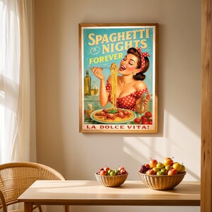 May include: A framed vintage-style poster with the text "Spaghetti Nights Forever" and "La Dolce Vita!" features a woman eating spaghetti. The poster is in a wooden frame and hangs on a beige wall. A wooden table with fruit baskets and a wicker chair are in front of the poster.