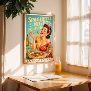May include: A framed vintage-style poster with the text "Spaghetti Nights Forever" and "La Dolce Vita!" features a woman enjoying spaghetti. The poster has a wooden frame and is displayed on a wooden table with a glass bottle of orange juice.