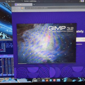 May include: A computer screen displays multiple windows. The main window shows the GIMP 3.2 image manipulation program interface with a galaxy image. Other windows include a terminal and a Tor Browser window.