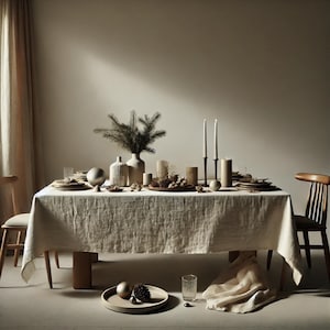 Könnte beinhalten: Eine rustikale festliche Tischdekoration mit einer weißen Leinentischdecke, Holzstühlen und einem Mittelstück aus Grün, Kerzen und Ornamenten.