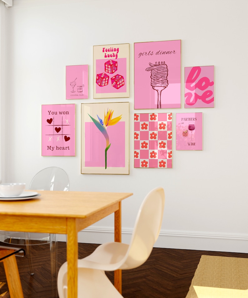 May include: A collection of eight pink and white framed prints with various designs, including dice, a flower, a heart, a glass of wine, and the words "Feeling Lucky", "Girls Dinner", "Love", "You Won", "My Heart", and "Partners in Wine".