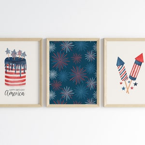 Pu&ograve; includere: Tre stampe incorniciate con un tema patriottico. La prima stampa presenta una torta rosso, bianco e blu con il testo "Buon compleanno America". La seconda stampa presenta uno sfondo blu con un motivo ripetitivo di fuochi d'artificio rosso, bianco e blu. La terza stampa presenta due fuochi d'artificio rosso, bianco e blu.