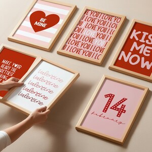 May include: A set of eight framed prints with Valentine's Day themes. The prints feature red and pink hearts, stripes, and text that says "Be Mine", "Kiss Me Now", "Valentine", "Make Your Heart The Prettiest Thing About You", and "14 February".