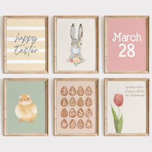 May include: Six framed wall art prints featuring Easter themes. Designs include a yellow striped print with 'happy Easter', a rabbit with flowers, a pink print with 'March 28', a yellow chick, a grid of patterned eggs, and a tulip with 'Spring is here'.