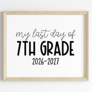 May include: A rectangular wooden frame containing a white sign with black text that reads: my last day of 7TH GRADE 2026-2027. The sign features a combination of cursive and bold sans-serif typography centered within the light-colored wood frame.
