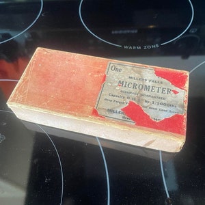 May include: A red box with white lettering that reads "One Millers Falls Micrometer Accuracy Guaranteed Capacity 0 to 1" by 1/1000ths Drop Forged F Cool Steel Lead Screw Miller Gree".