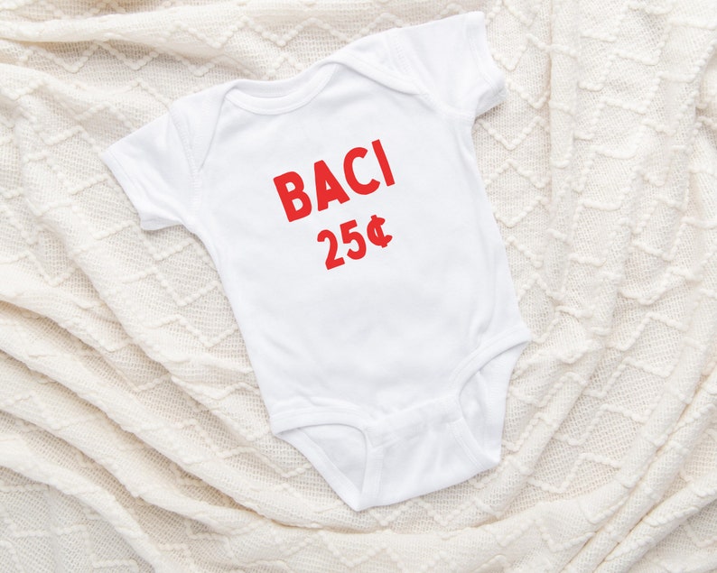 May include: White baby onesie with red text that says "BACI 25&cent;".