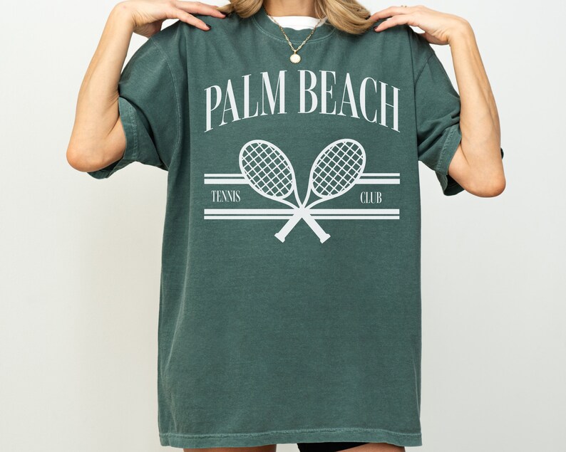 May include: A green t-shirt with the text "PALM BEACH TENNIS CLUB" and a graphic of two crossed tennis rackets.