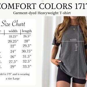 May include: A charcoal grey Comfort Colors 1717 garment-dyed heavyweight t-shirt. The image includes a size chart with width and length measurements in inches for sizes S through 4XL, noting a model height of 5'9" wearing a size Large.