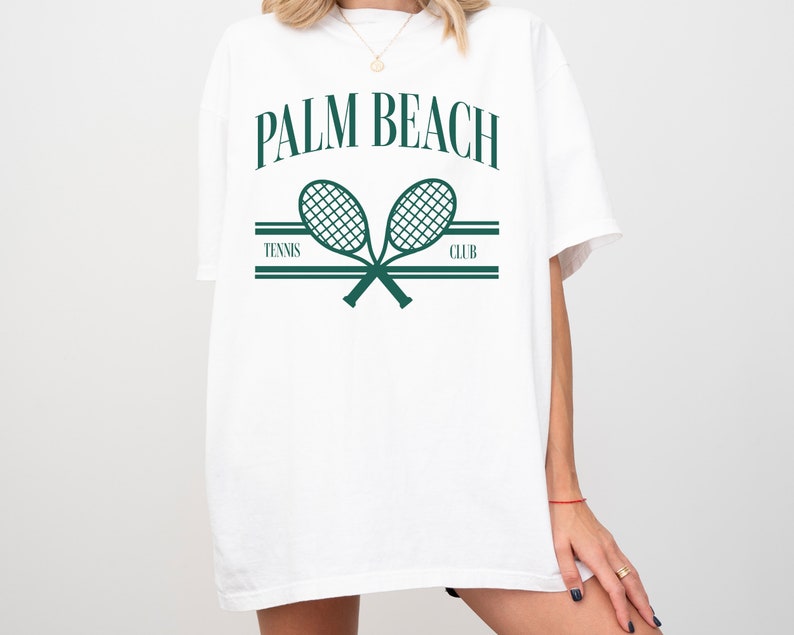 May include: White t-shirt with a green graphic of two crossed tennis rackets and the text "PALM BEACH TENNIS CLUB".