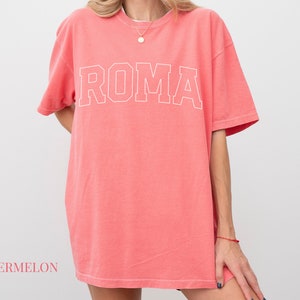 May include: A watermelon-colored oversized t-shirt with the word "ROMA" printed in white on the front.