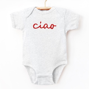 May include: A gray short-sleeved bodysuit with the word "ciao" in red lettering.