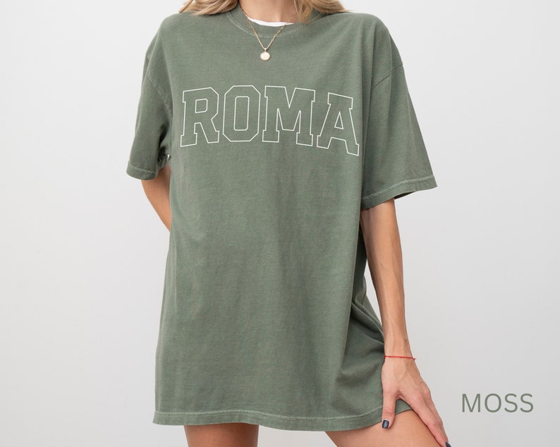 May include: A green oversized t-shirt with the word "ROMA" printed in white on the front.