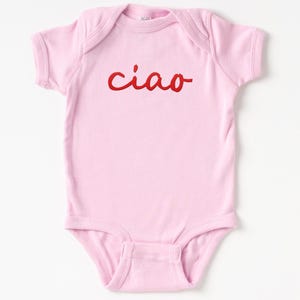 May include: Pink baby onesie with the word "ciao" in red cursive lettering.