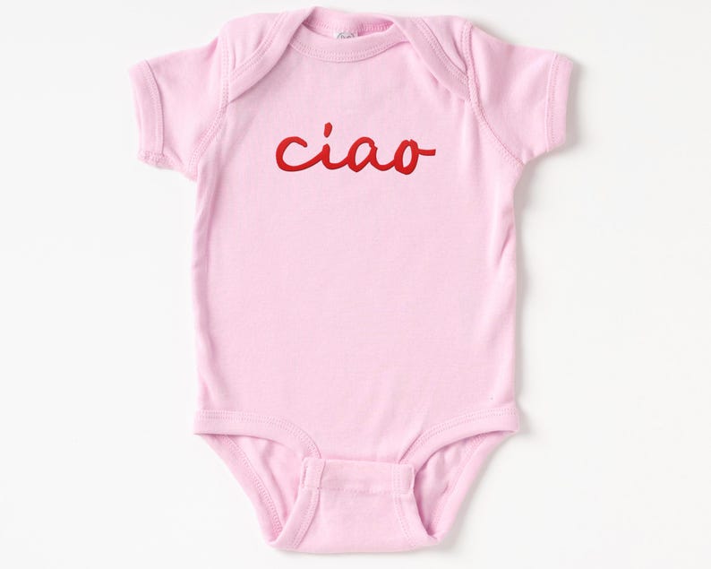 May include: Pink baby onesie with the word "ciao" in red cursive lettering.