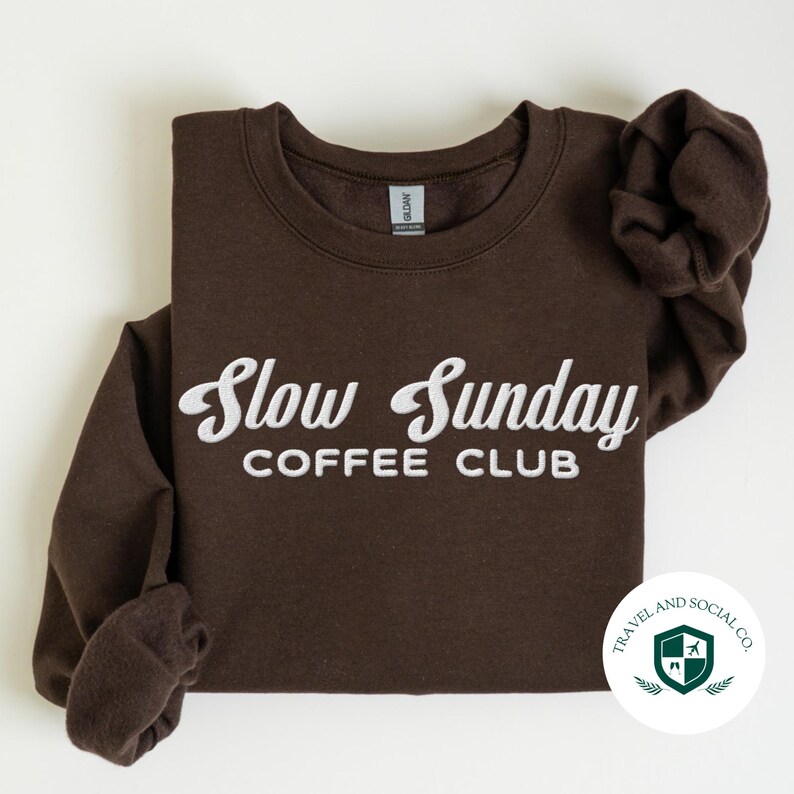 May include: Brown sweatshirt with white embroidered text that reads "Slow Sunday Coffee Club".