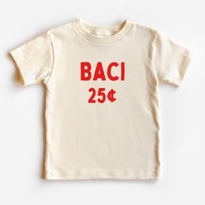 May include: A cream colored t-shirt with red text that says "BACI 25&cent;".