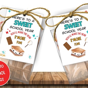 May include: Two clear cellophane bags filled with chocolate and marshmallows, each tied with twine and a tag. The tags read "Here's to a Sweet School Year" with s'mores graphics. A red circle says "Back to School Tags."