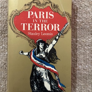 Pode incluir: Um livro de bolso intitulado Paris in the Terror de Stanley Loomis com capa dourada. A frente apresenta uma moldura decorativa vermelha, uma ilustração a preto e branco de uma figura segurando uma espada e uma faixa vermelha, branca e azul.