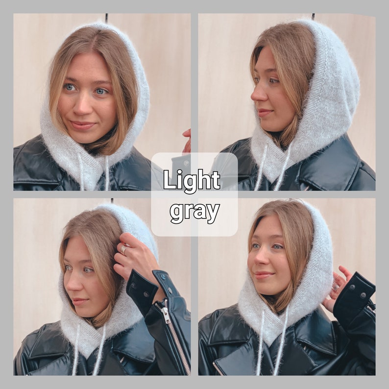 May include: A woman wearing a light grey hooded sweater over a black leather jacket. The hood is pulled up over her head. The woman is looking to the side.