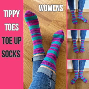 Pode incluir: Um par de meias listradas em tons de rosa e turquesa, com o texto "WOMENS" visível no fundo. As meias estão sendo usadas por uma pessoa com o jeans dobrado.