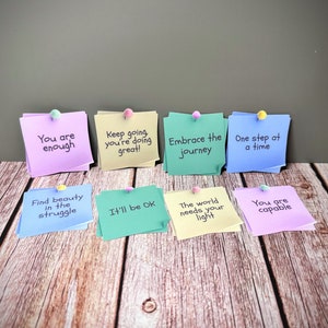 Puede incluir: Ocho notas adhesivas de colores con mensajes inspiradores, como "You are enough", "Keep going you're doing great!" y "Embrace the journey".