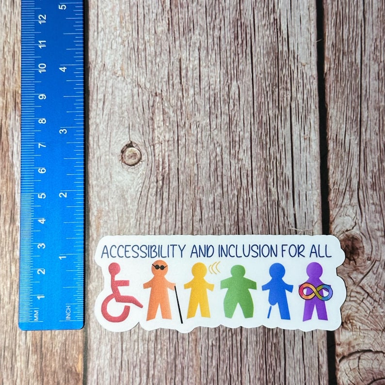 以下が含まれることがあります： 「ACCESSIBILITY AND INCLUSION FOR ALL」の文字と、さまざまな障害を持つ人々を表すカラフルな棒人間が描かれた白いステッカー。ステッカーの左側には、12cmまで測れる青い定規があります。