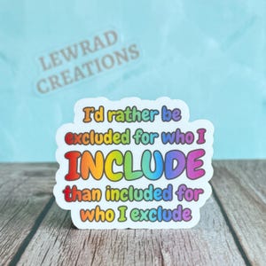 May include: A white sticker with the text "I'd rather be excluded for who I INCLUDE than included for who I exclude" in rainbow colors. The sticker also has the text "LEWRAD CREATIONS" in the upper left corner.