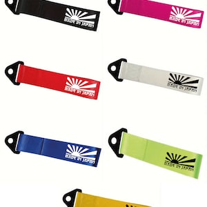 Può includere: Sei cinghie di traino di colori diversi con un anello di metallo nero a un'estremità e un logo di sole nascente bianco con il testo "MADE IN JAPAN" all'altra estremità. I colori sono nero, rosa, rosso, bianco, blu, verde e giallo.