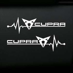 Puede incluir: Calcomanías de vinilo blanco con la palabra "CUPRA" en negrita, sin serifa, acompañada de un gráfico de latido cardíaco estilizado. Las calcomanías están diseñadas con una estética moderna, adecuadas para aplicaciones automotrices. El fondo es negro.