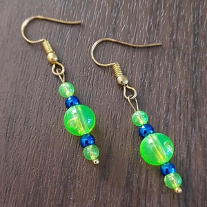 May include: A pair of earrings with green and blue beads. The earrings are made of gold metal and have a simple design.