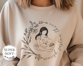May include: A beige sweatshirt with a black and white illustration of a woman breastfeeding a baby. The illustration is surrounded by floral designs and the text "nourish sustain love".