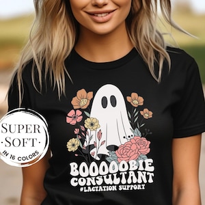 May include: Black t-shirt with a white ghost and floral design. The text on the shirt reads "Boo-oobie Consultant #Lactation Support".