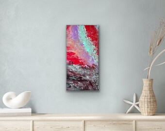 May include: Abstract painting with red, pink, purple, and blue colors. The painting has a textured, layered look, with a dark gray base.