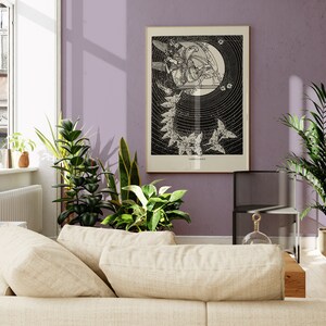 May include: A black and white illustration of a woman playing a harp in a cage surrounded by vines. The illustration is framed and hanging on a light purple wall.