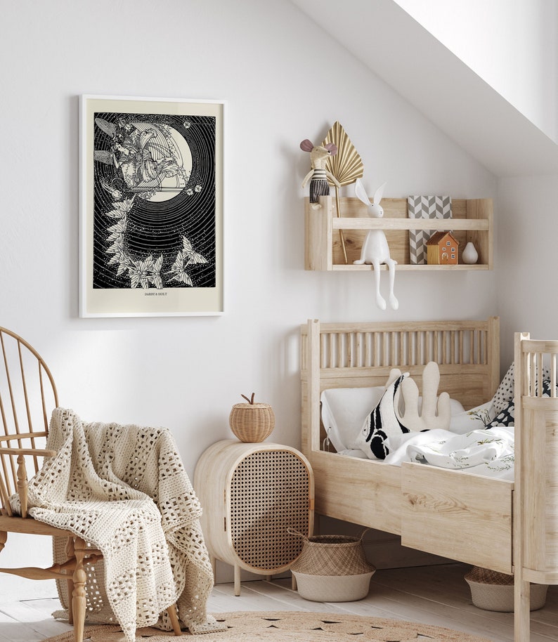 May include: A black and white illustration of a woman riding a bird with a crescent moon in the background. The illustration is framed and hanging on a white wall above a wooden bed with a white and black patterned pillow. The bed is in a room with a wooden chair and a woven basket.