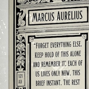 May include: Black and white framed print with a quote by Marcus Aurelius. The quote reads "Forget everything else. Keep hold of this alone and remember it: Each of us lives only now, this brief instant. The rest..." The print also includes the years 121 AD and 180 AD.