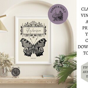 Peut inclure: Une illustration vintage en noir et blanc d'un papillon avec le texte "Fly.befree" dans un cadre d&eacute;coratif. L'illustration est sur un fond cr&egrave;me et est encadr&eacute;e dans un cadre blanc.