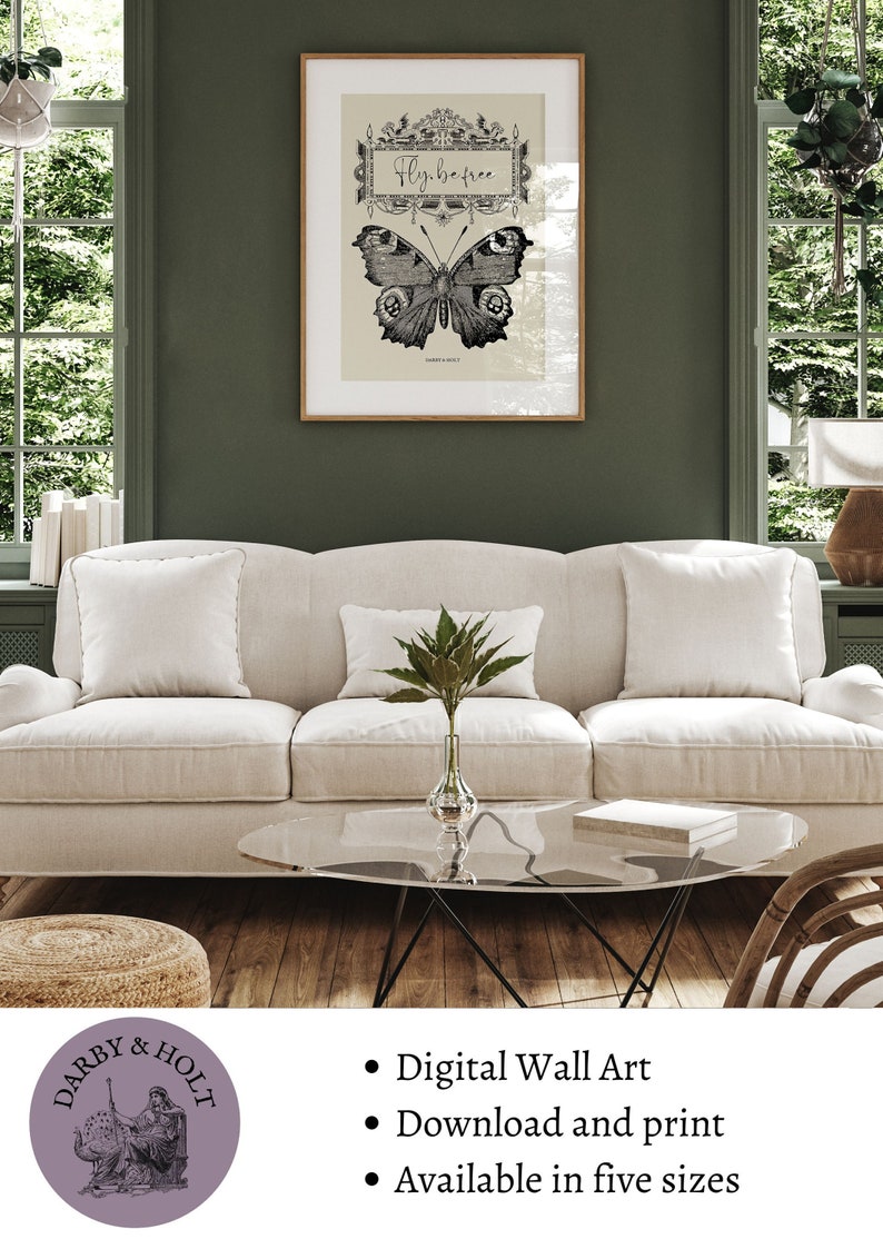 Peut inclure: Une impression d'art mural num&eacute;rique repr&eacute;sentant une illustration en noir et blanc d'un papillon avec le texte "Fly be free". L'impression est encadr&eacute;e et affich&eacute;e sur un mur dans un salon.