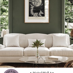 May include: A black and white illustration of a woman with wings flying through the air. The illustration is framed and hanging on a green wall above a white couch. The text "Darby & Holt" is visible in the lower left corner of the image. The text "Digital Wall Art", "Download and print", and "Available in five sizes" is visible in the lower right corner of the image.