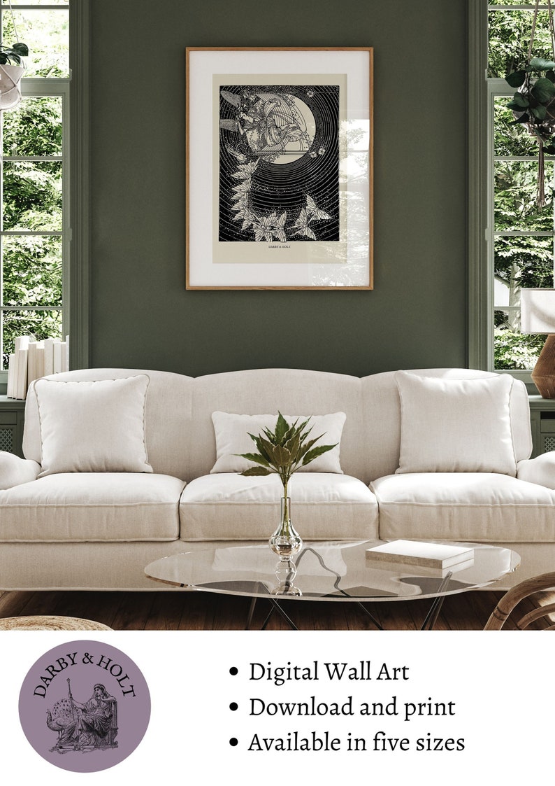 May include: A black and white illustration of a woman with wings flying through the air. The illustration is framed and hanging on a green wall above a white couch. The text "Darby & Holt" is visible in the lower left corner of the image. The text "Digital Wall Art", "Download and print", and "Available in five sizes" is visible in the lower right corner of the image.