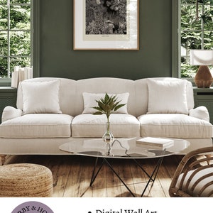 K&ouml;nnte beinhalten: Eine Schwarzwei&szlig;illustration einer Frau in einem Wald, gedruckt auf wei&szlig;em Hintergrund und in einem Holzrahmen gerahmt. Der Druck h&auml;ngt an einer gr&uuml;nen Wand &uuml;ber einem wei&szlig;en Sofa. Der Text "DARBY & HOLT" ist in einem violetten Kreis mit einer Schwarzwei&szlig;illustration einer Frau, die auf einem Pfau sitzt, sichtbar.