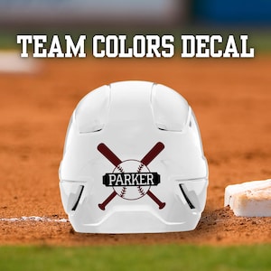 May include: A white baseball helmet with a maroon baseball and crossed bats decal. The decal includes the name "PARKER" in a black rectangle. The text "TEAM COLORS DECAL" is above the helmet.