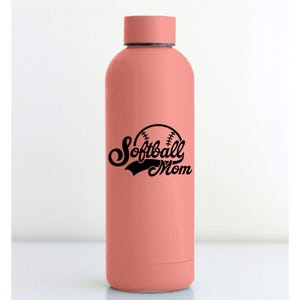 May include: A coral-colored water bottle with a matching cap. The bottle features a black graphic of a softball with the words "Softball Mom" in a script font. The bottle is designed to keep drinks cold or hot.