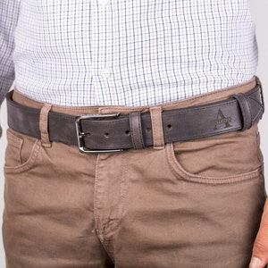 May include: A brown leather belt with a silver buckle and the name "Antonio" engraved on the strap.