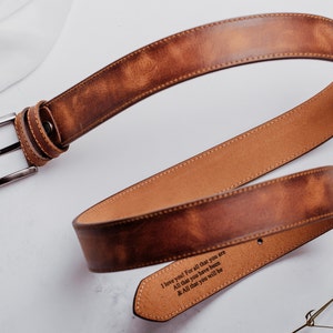 May include: A brown leather belt with a silver buckle. The belt has an engraved message that reads "I love you! For all that you are All that you have been & All that you will be".