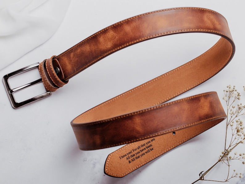 May include: A brown leather belt with a silver buckle. The belt has an engraved message that reads "I love you! For all that you are All that you have been & All that you will be".