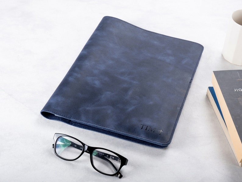Puede incluir: Una carpeta de cuero azul oscuro con una inscripci&oacute;n personalizada que dice "TIM +"